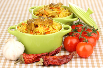 Delicious pilaf with vegetables on tablecloth background