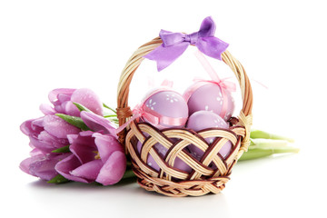 Bright easter eggs in basket and tulips, isolated on white