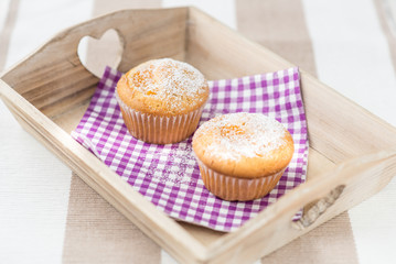 two tasty muffins muffins at a wood tray