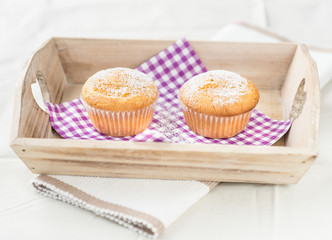 two tasty muffins muffins at a wood tray