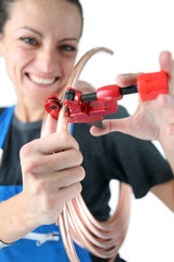 Female plumber cutting copper pipe