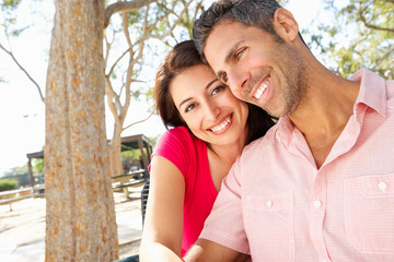 Fototapeta premium Romantic Couple Sitting On Park Bench Together