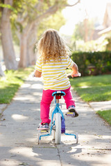 Fototapeta premium Girl Learning To Ride Bike On Path