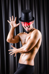 Muscular actor with mask against curtain