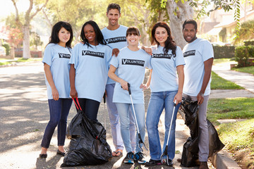 Team Of Volunteers Picking Up Litter In Suburban Street