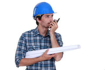 Engineer with plans and a walkie talkie