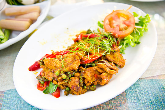 Dried pork with spicy curry on white plate in restaurant