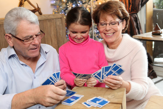 Little Girl Playing Cards With Her Grandparents