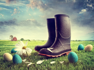 Rubber boots with easter eggs on grass