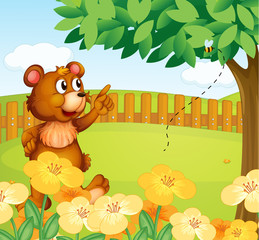 Ein Bär im Zaun zeigt auf eine Biene