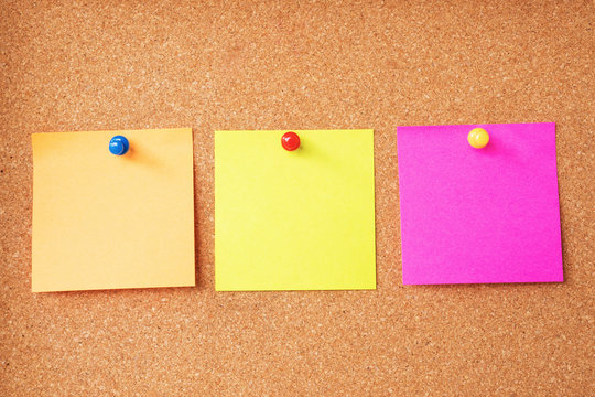 Colorful sticky notes on cork board