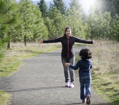 Mom And Daughter Running In A Park