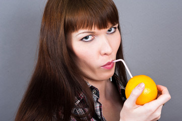 beautiful woman drinking a cocktail of orange
