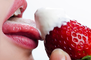 Obraz premium woman licks sour cream with strawberry