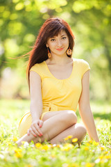 Young happy woman in the park with flowers