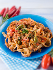tagliatelle with tuna tomatoes and capers, selective focus