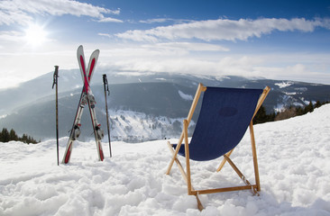 Naklejka na ściany i meble Cross ski and Empty sun-lounger at mountains in winter