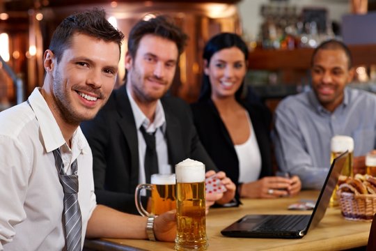 Young office worker drinking beer at pub