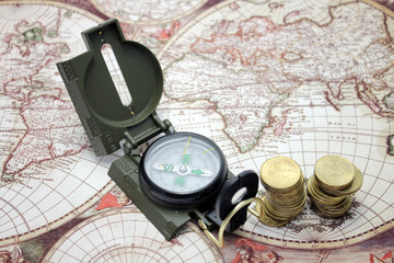 Money and compass lie on the background of the map of the world