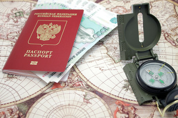 Паспорт, деньги и компас лежат на карте мира