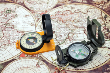 Obraz na płótnie Canvas Dwa kompas leżą na tle mapy świata