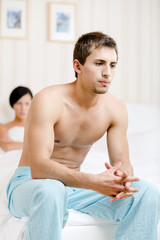 Young couple argues in bed-room