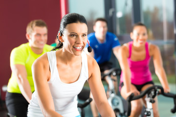 Group of people spinning on bikes in gym
