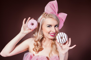 Donuts. Funny woman eating donuts smiling in studio