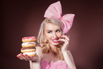 Donuts. Funny woman eating donuts smiling in studio