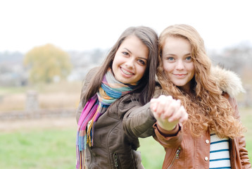 Brunette and blond haired girls friends laughing