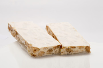 Pieces of Christmas hard almond turron on white plate