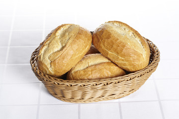 Korb mit Brötchen auf Damastdecke