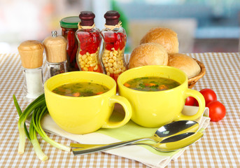 Fragrant soup in cups on table in kitchen