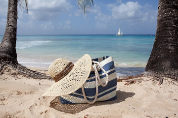 beach hat and bag on the sand - obrazy, fototapety, plakaty
