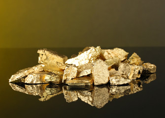 Golden nuggets on dark yellow background