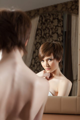 Naklejka premium Reflection of attractive young brunette in mirror