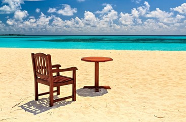 Fototapeta na wymiar Krzesła i stół są na plaży