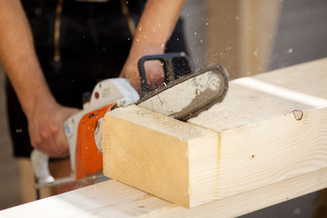 zimmermann sägt holzbalken
