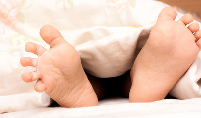 Obraz na płótnie Canvas Baby feet under a blanket