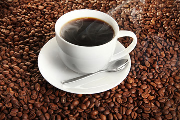 Cup of coffee on coffee beans background