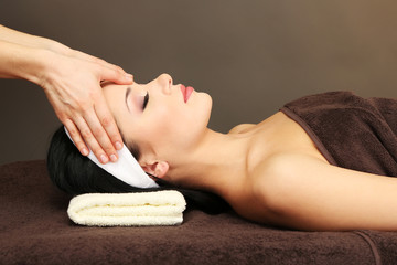 Obraz na płótnie Canvas Beautiful young woman in spa salon taking head massage,