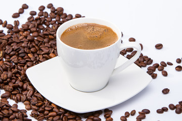 Cup of coffee among coffee beans