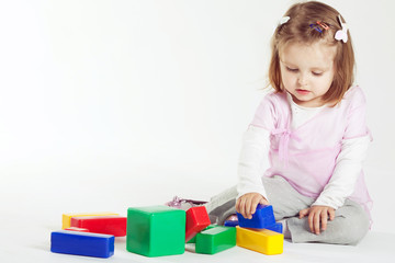 little girl plays with cubes
