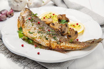 Roasted fish with lemon, mushrooms and herbs