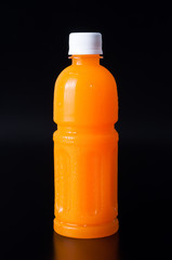 orange juice in a bottle on black background