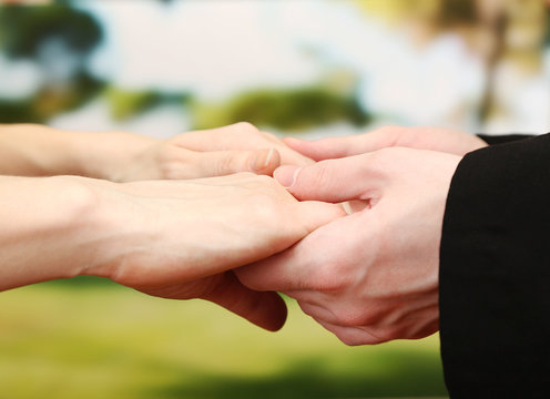 Priest holding woman hands, on green background