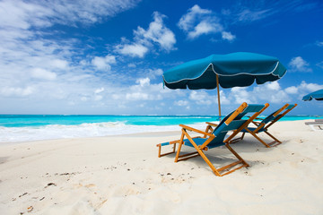 Chairs and umbrella on tropical beach © TravelPhotoBloggers