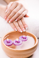 beautiful female hands with aromatic candles and towel. Spa