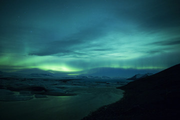 Fototapeta premium Northern lights above lagoon in Iceland
