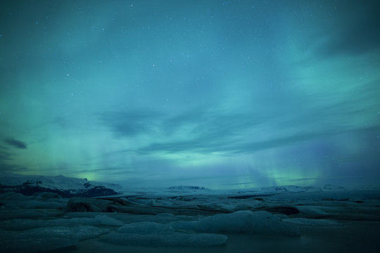 Northern lights above lagoon in Iceland © jamenpercy